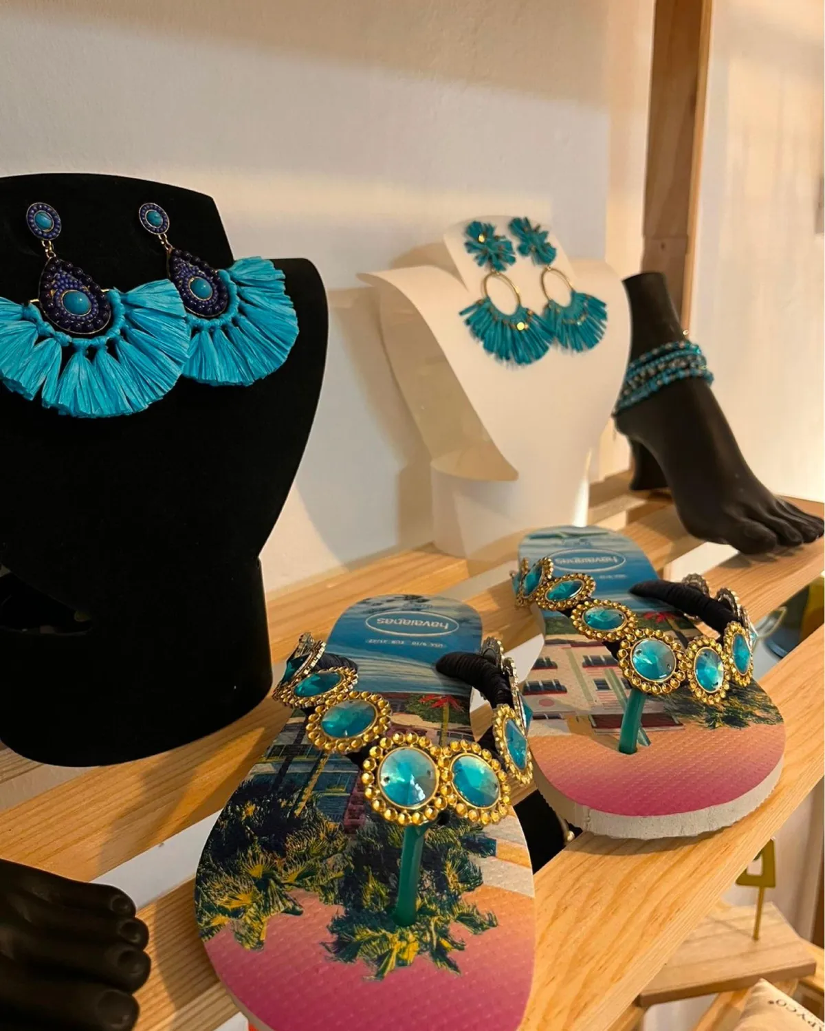 Bijoux et sandales ornées présentés en boutique à Jarry
