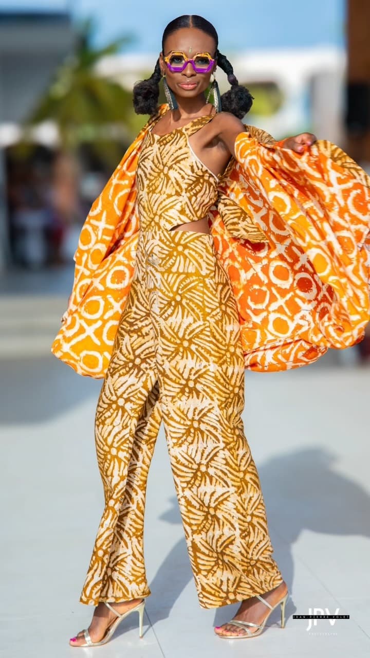 Combinaison en batik ocre avec cape assortie orange, portée avec des sandales dorées