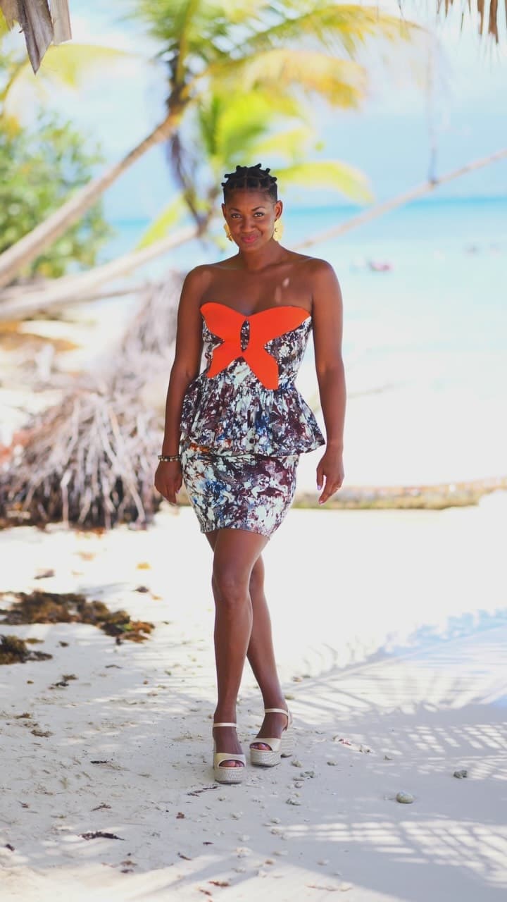 Robe bustier péplum imprimée à motif papillon orange, portée en bord de mer en Guadeloupe